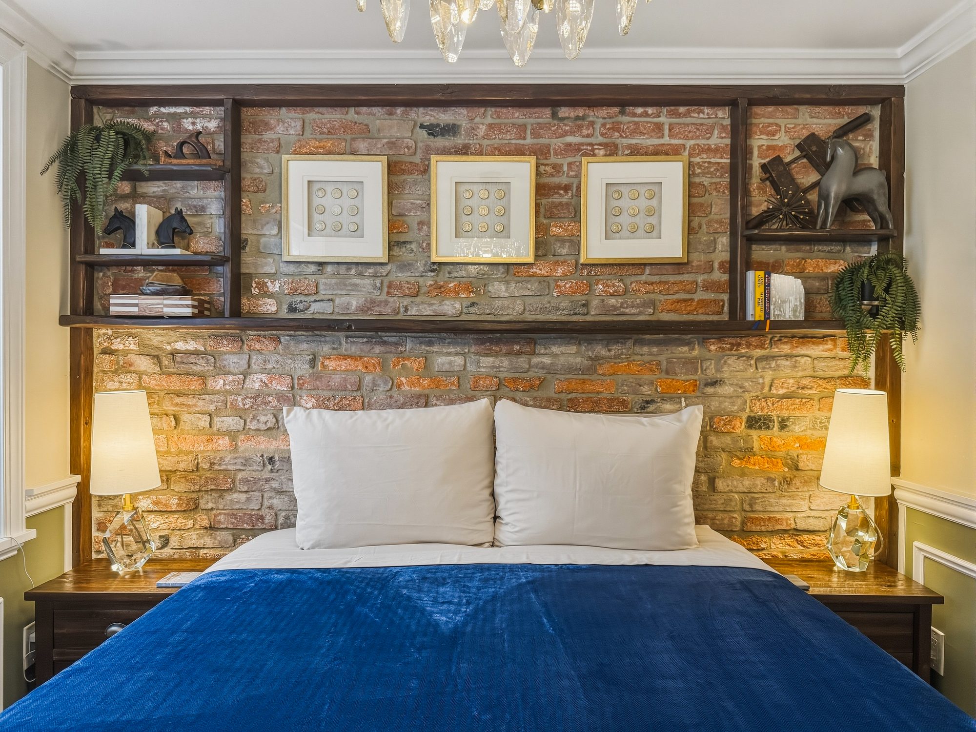 Quiet bedroom with exposed brick and a navy bedspread