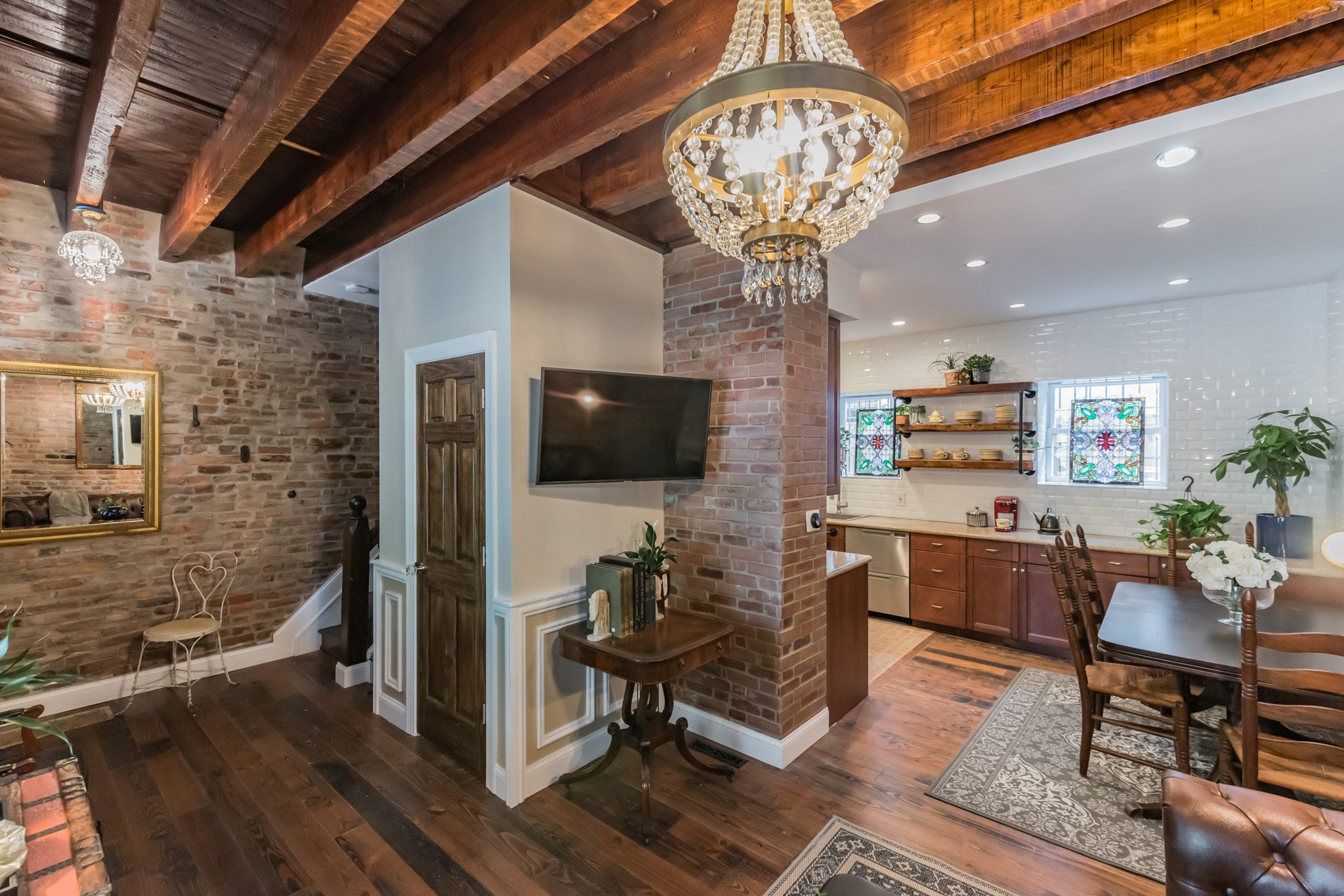 Historic living room with exposed brick, beams and chandelier